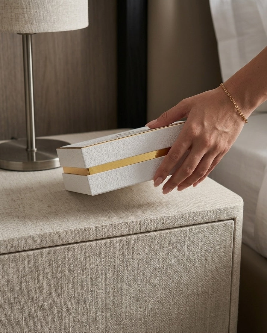 Hand placing the BcauseU gift box on a bedside table